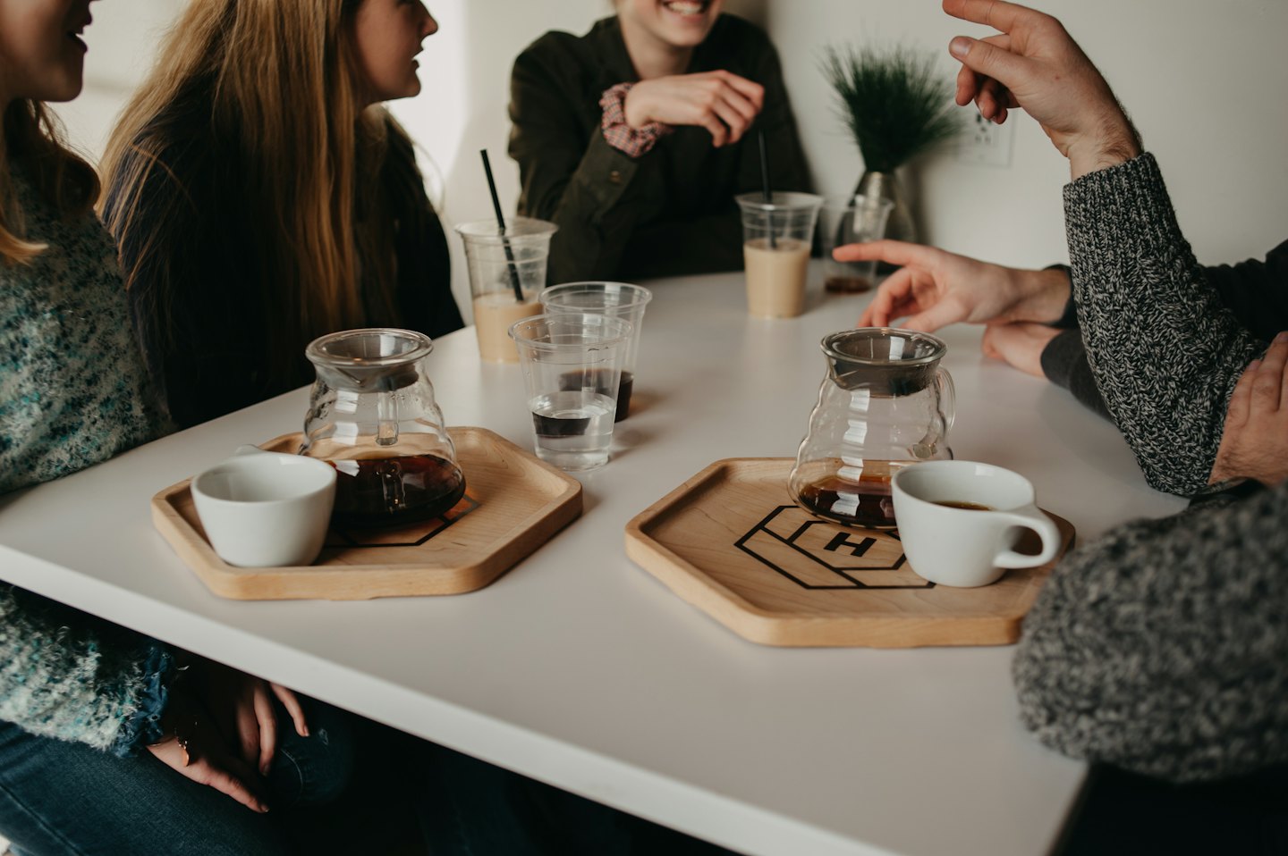 Folk som pratar över kaffe vid ett kafébord.
